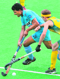 Indias Birendra Lakra Singh (L) and Matthew Swann of Australia tangle sticks during the second semifinal at the men's Hockey Champions Trophy tournament in Melbourne on Saturday