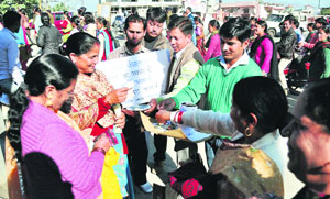 Agitating shiksha mitras beg near the Vidhan Sabha to highlight their plight in Dehradun
