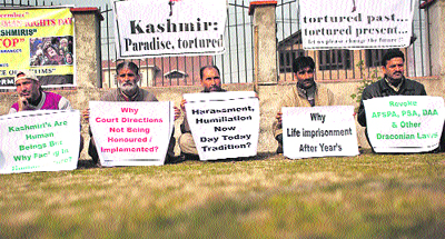 Members of the Jammu and Kashmir Joint Voice of the Victims hold placards during a sit-in ahead of Human Rights Day in Srinagar on Sunday. They were demanding justice for victims of torture, rapes, custodial killings, fake encounters and massacres that occurred over the last two decades.