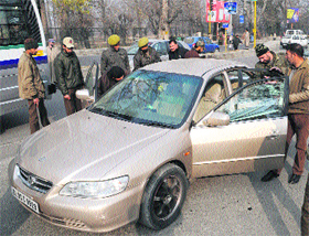 Policemen remove tinted glasses on a private vehicle at a checkpoint in Srinagar on Sunday. 