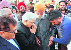 Union Law Minister Ashwani Kumar with slain police official Ravinderpal Singhs father at the deceaseds house in Rampura village of Amritsar on Sunday.