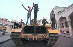 Anti-Mursi protesters stand on a military tank in front of the Presidential Palace in Cairo on Sunday
