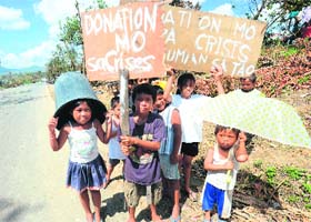 Children beg for alms at Osmena town in Compostela Valley province on Sunday