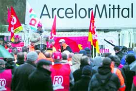 Striking steel workers gather at the entrance of the ArcelorMittal plant in Basse-Indre, western France, on Monday. ArcelorMittal infuriated many on the French Left by announcing that it would shutdown a blast furnace in northeast France.
