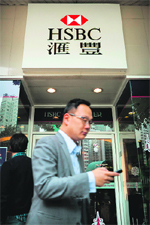 A pedestrian walks past an HSBC branch in Hong Kong. 