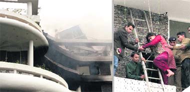 Smoke billows out of Hotel Solitaire Inn in Dehradun; and (right) a couple staying in the hotel being rescued by fire personnel on Tuesday