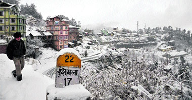 A man walks during this seasons first snowfall at Kufri, 17 km from Shimla, on Tuesday.