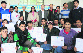 Reasi Deputy Commissioner Nirmal Sharma poses for a photograph along with SBI officials and youth at the valedictory function of a training programme in Reasi on Tuesday.