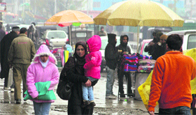 A woman walks on a footpath along with her child in Srinagar on Tuesday.
