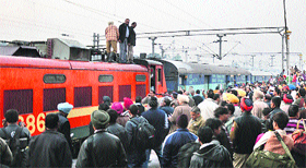 Anxious passengers wait for the firefighters to douse the flames at the Ludhiana railway station on Tuesday.