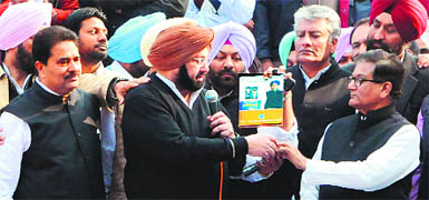 Punjab Congress chief Amarinder Singh and CLP Leader Sunil Jakhar, with a copy of a directory on Akali leaders provided to various police stations, at a party demonstration in Amritsar on Tuesday. 
