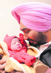 Preet Kanwar, father of a baby born on 12.12.12 looks at his daughter in Sector 19, Chandigarh, on Wednesday. 
