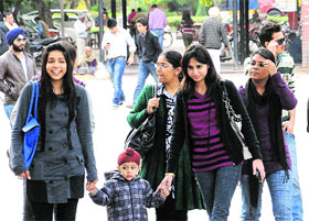 Residents in warm clothes on a windy day at Sector 17 in Chandigarh on Thursday.