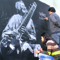 Adieu maestro: Artist Amit gives final touches to the portrait of Pandit Ravi Shankar on a wall of the Punjab Press Club in Jalandhar on Wednesday. Tribune photo: Malkiat Singh