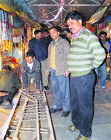 Police and municipal officials remove encroachments on a road in the Mandir Bazar in Kangra on Thursday.