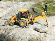 A JCB machine being used to fill killer point in the Banner khud near old Kangra on Thursday. 