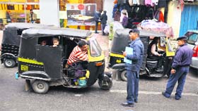 Traffic policemen challan autorickshaws in Jammu on Thursday