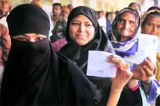 Women wait in a queue to cast their vote at a polling station in Dholka near Ahmedabad on Thursday.