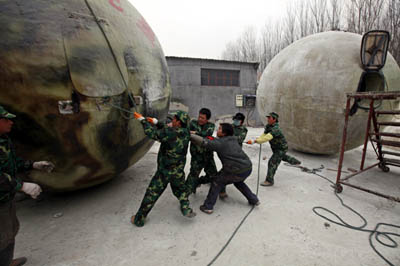 Workers try to adjust the position of a spherical pod named Noahs Ark, designed by Chinese inventor Liu Qiyuan, in Xianghe, Hebei province, on Wednesday.