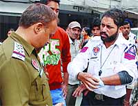Traffic cop Sardara Singh shows his injured wrist to a policeman in Amritsar on November 24