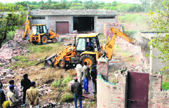 A demolition drive being carried out on the outskirts of Daria village near the Chandigarh railway station on Friday.