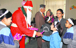 Santa Claus distributes gifts to students of Indian Cambridge School during the Christmas celebrations in Dehradun on Friday. 