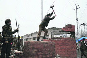 CRPF personnel removing a bunker from the Amira Kadal bridge in Srinagar on Friday.