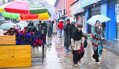 Residents walk around in the market on a cold day after heavy rain and snowfall in the Kashmir valley on Friday.
