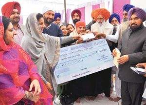Preneet Kaur hands over a cheque of Rs 25 lakh for construction of a bridge at Amlala village on Saturday.