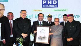 President Pranab Mukherjee being presented his portrait by PHDCCI president Sandip Somany while Himachal Chief Minister PK Dhumal, Chhattisgarh CM Raman Singh and Uttarakhand CM Vijay Bahuguna look on at a function of the PHD Chamber of Commerce and Industry in New Delhi on Saturday.