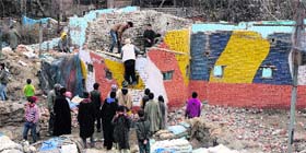People dismantle one of the oldest CRPF bunkers in the Batamaloo area of Srinagar on Saturday.