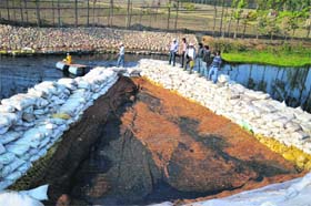 A wire mesh to segregate solid waste in the nullah near Jainpur village