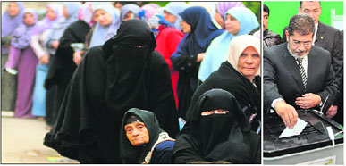 Women queue up outside a polling station in Alexandria on Saturday; and President Muhamed Mursi casts his vote on a new Constitution in Cairo. 