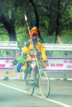 A nihang pedals his way on the Bathinda-Barnala road.
