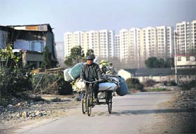 A scavenger cycling in a construction waste garbage dump in Hefei, central China's Anhui province. China's wealth gap has widened to a level where it is among the world's most unequal nations, a Chinese academic institute said in a survey, as huge numbers of the poor have been left behind by the economic boom