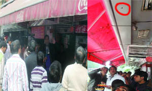 People gather around the dhaba after the shooting incident near Shivaji Stadium, Connaught Place in New Delhi on Sunday. 