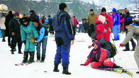 Tourists have fun skiing near Manali after fresh snowfall on Sunday.