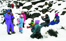 Tourists throng Nehru Kund after fresh snowfall on Sunday.