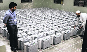 ALL SET: Election officials with EVMs at a distribution centre in Gujarat. 