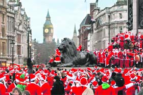 Revellers dressed up in Santa outfits gather at Trafalgar Square in London during a Santacon festival parade on Saturday