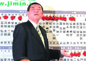 Japan's main Opposition Liberal Democratic Party Secretary General Shigeru Ishiba attaches rosettes next to successful general electoral candidate names on a board at the party headquarters in Tokyo on Sunday