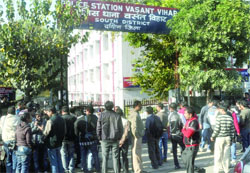 People and mediapersons gather outside the Vasant Vihar police station after a gangrape in New Delhi on Monday.