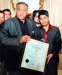 Uttarakhand Chief Minister Vijay Bahuguna honours Aman Rehman, a young animator, in Dehradun on Monday.