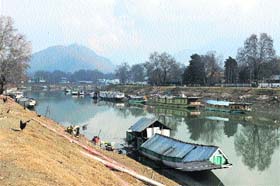 Houseboats are seen parked along the banks of the Jhelum in Srinagar on Monday