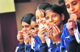 Winners of the National Blind Games kiss their medals in Ludhiana. 