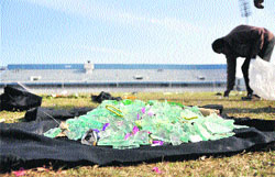 A worker picks up broken glass scattered at the Guru Nanak Dev Satdium in Ludhiana on Monday.