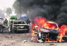 A burning car at the site of the bomb blast at Fauji Market in Peshawar on Monday. 