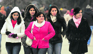 Girls covered with heavy woollens to protect themselves from cold in Shimla recently.