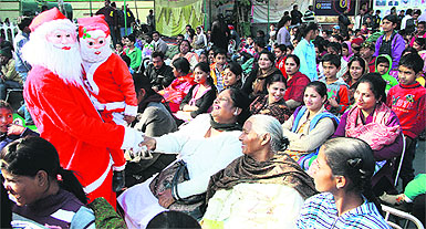 A Santa Claus shakes hands with a woman during a shobha yatra organised by the Christian community in Jalandhar on Tuesday. 