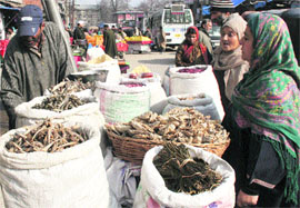 Women purchase dried vegetables from a vendor in Srinagar. 